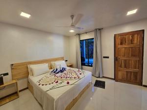 a bedroom with a bed and a wooden door at Sunset Beach View in Dhangethi