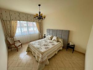 a bedroom with a bed and a chair and a window at Casa en playa Rio Sieira in Porto do Son