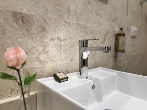 a bathroom sink with a faucet and a pink rose at Boutique Hotel Casa Grande, Dominican Voyage, Suite familiar de 2 dormitorios in Santo Domingo +27 photos