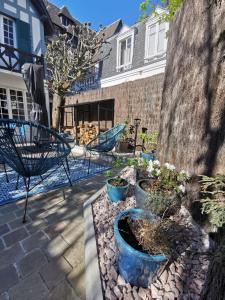 a patio with three blue pots with plants in it at Villa normande - Les Crapauds Fous - proximité Centre Ville et Plage in Deauville