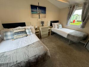 une chambre avec deux lits et une fenêtre dans l'établissement Fantasy Island Resort - The Pearl, with Hot Tub - Coastal Caravan Breaks, à Ingoldmells