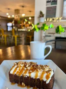 a piece of cake on a white plate on a table at Bumblebee Bight Inn in Pilleyʼs Island