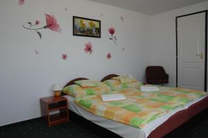 1 dormitorio con 1 cama con un edredón colorido en Bélkő Panzió, en Bélapátfalva