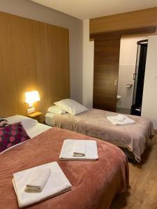 a hotel room with two beds with towels on them at Hôtel Le Saint Amand in Saint-Amand-Montrond