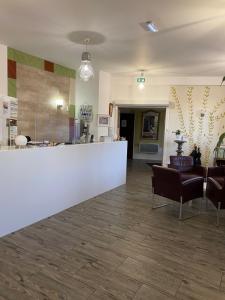 a lobby with a white counter and some chairs at Hôtel Le Saint Amand in Saint-Amand-Montrond