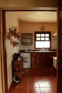 a kitchen with a sink and a washing machine at Casa Las Sabinas in Guarazoca