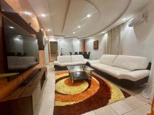 a living room with a couch and a tv at Villa Paco in Mbour