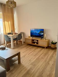 una sala de estar con un televisor y una mesa en Ares Peñiscola, en Peñíscola