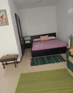 a bedroom with a purple bed and a chair at Apartamento en Playa de Madrid in San Martín de Valdeiglesias +4 photos
