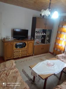 a living room with a table and a tv at Seosko domaćinstvo Desin Do in Berane +12 photos