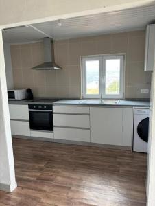 a kitchen with white cabinets and a stove top oven at Casa bela paisagem in Castro Daire +15 photos