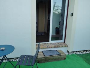 a patio with a chair and a table and a mirror at Studio cosy sans vis-à-vis in Vernon