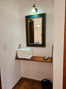 トゥライヤカパンにあるHotel Boutique La Renacuajaのバスルーム(鏡、タオル付きの棚付)
