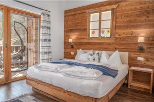 a bedroom with a bed with a wooden wall at Alpine Mountain Chalet in San Vigilio Di Marebbe