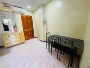 a room with a table and chairs and a dresser at SahaLand Siargao Guest House in General Luna