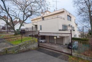 a white house with a gate in front of it at White Rose Hill Luxury Apartment Budapest in Budapest
