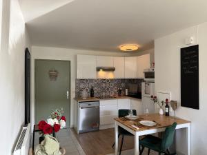 a kitchen with a table and a dining room at Suite Eden Spa, Appart'hôtel bien être , Patio de standing barbecue - TV XL CinéSport, Lit Q-Size, Wifi, P-Gratuit en Résidence in Avion