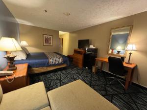 a hotel room with a bed and a desk at VICTORIAN INN in Central City