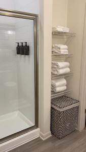 ein Bad mit einer Dusche, einem Spiegel und Handtüchern in der Unterkunft Atlanta Beltline Luxury Double Suite in Atlanta