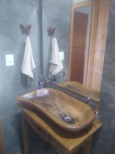 un bagno con un lavandino in legno e uno specchio di Casa Casoli - Perfeita para família e amigos a Bueno Brandão
