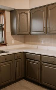 a kitchen with brown cabinets and white counter tops at The Mueller Haus in Hermann +14 photos