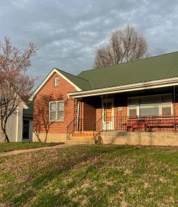 a red brick house with a green roof at The Mueller Haus in Hermann