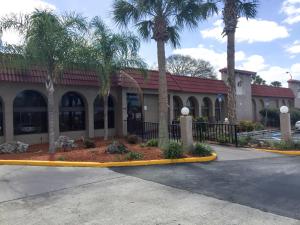 a building with palm trees in front of it at Motel 6-Spring Hill, FL - Weeki Wachee in Weeki Wachee