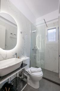 a bathroom with a sink and a toilet and a shower at Philoxenia Apartments Saranda in Sarandë