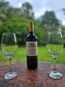 a bottle of wine and two glasses on a table at Rio Sereno Suítes Comfort - Lumiar in Lumiar