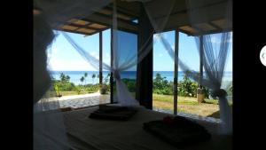 a bedroom with a bed with a view of the ocean at Ocean Plateau in Motu Tiahura