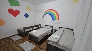 a room with two beds and a rainbow on the wall at Guest house Boljević in Rap