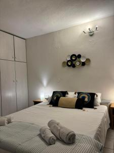 a bedroom with two beds and a clock on the wall at Cozy apartment by Athens in Athens