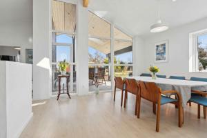 a white dining room with a table and chairs at Lovely Bright House Near The Beach In Nature in Ørsted