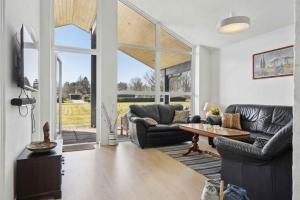 a living room with couches and a table at Lovely Bright House Near The Beach In Nature in Ørsted