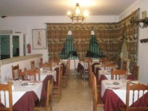 a dining room with tables and chairs in a restaurant at Hostal Malia in Conil de la Frontera