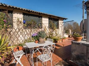 eine Terrasse mit 2 Stühlen und einem Tisch mit Topfpflanzen in der Unterkunft Over The Tiber Loft in Rom