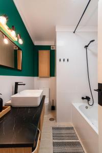 a bathroom with a white tub and a green wall at Casa Galicia in El Médano