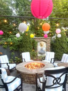 een patio met een vuurplaats met stoelen en lantaarns bij A beautiful award winning bungalow in Indianapolis