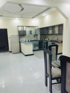a large kitchen with a glass table and chairs at Moon Residence in Karachi