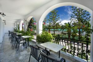 a row of tables and chairs on a balcony with a view at Hotel Athina in Karavomylos