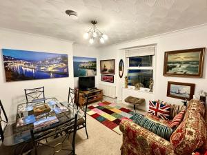 a living room with a couch and a glass table at Seaway Beach House Looe Beach in Looe