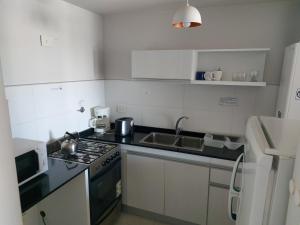a small kitchen with a stove and a sink at Departamento Céntrico in Puerto Madryn