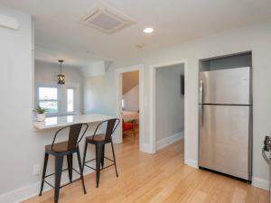 a kitchen with a refrigerator and two bar stools at Jennifer's Historic College Hill Apartment - The Lookout in Providence +25 photos