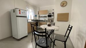 a kitchen with a table and chairs and a refrigerator at Apto no centro de Torres | Aceita Pet in Torres +8 photos