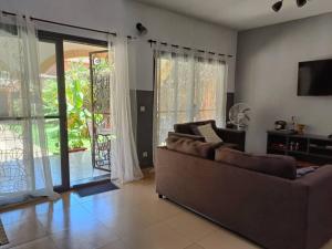 a living room with a couch and a sliding glass door at Villa Na aldiana in Sali Nianiaral