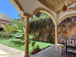 an outdoor patio with a stone wall and a fence at Villa Na aldiana in Sali Nianiaral