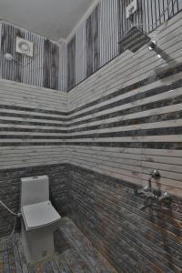 ein Badezimmer mit Toilette und einer Ziegelwand in der Unterkunft Hotel Ramayan Premium Best Family Hotels with Free Pickup From Ayodhya Dham Railway Station in Ayodhya