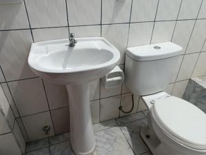 a bathroom with a white sink and a toilet at Hospedaje Cielo Marino in Zorritos