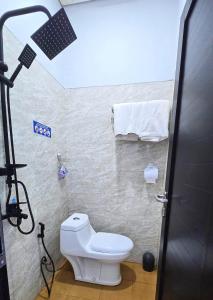 a bathroom with a white toilet and a light at Laswi Syariah Guest House in Bandung +9 photos