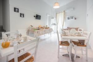 a white dining room with white tables and chairs at B&B Casa Giunchiglia in Noto